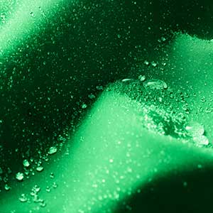 Green fabric with water droplets depicting a Durable Water Repellent Finish
